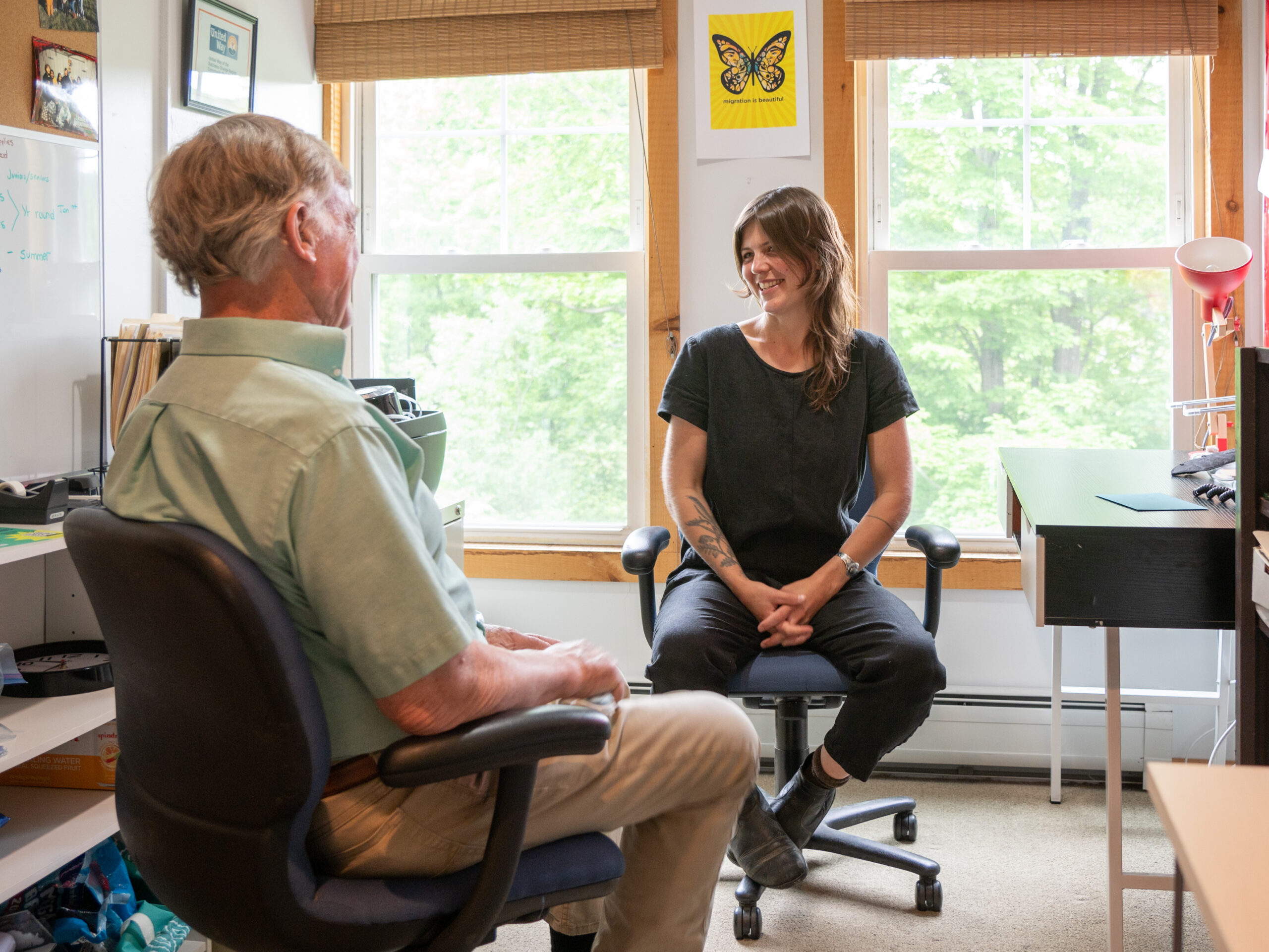 Two people sit together in conversation.