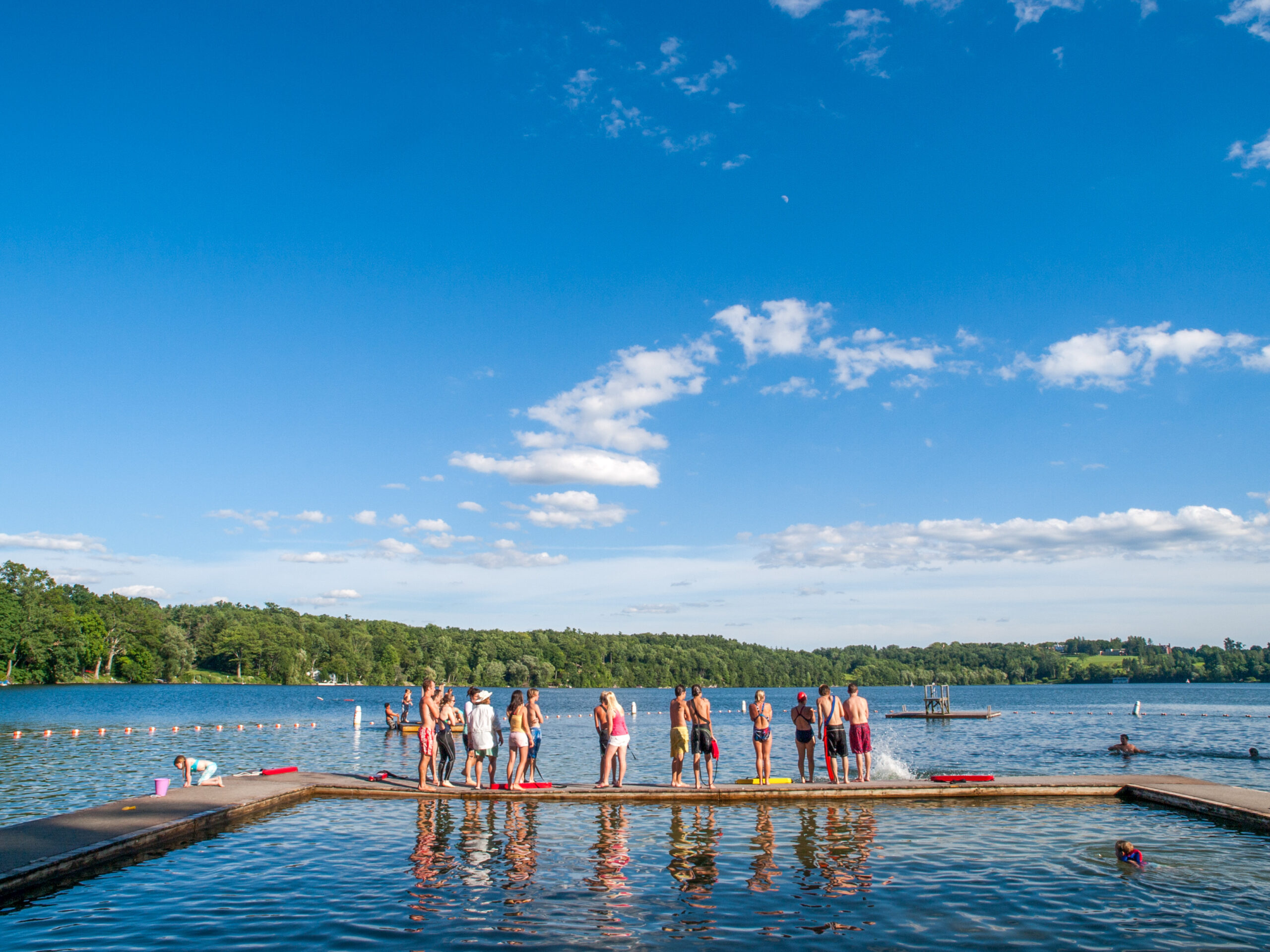 Youth waiting on swimming docks on a lake.